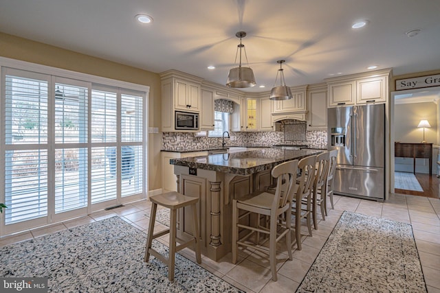 4408 Irish Creek Rd, Bernville, PA 19506 - kitchen featuring appliances with stainless steel finishes, cream cabinets, light tile patterned floors, backsplash, and a kitchen island