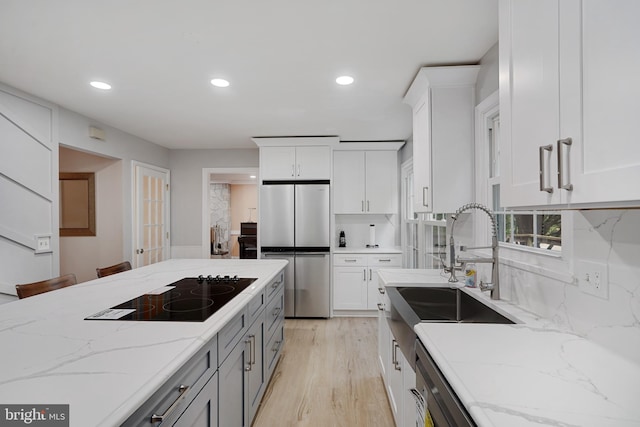 10401 Zion Dr, Fairfax, VA 22032 - kitchen with stainless steel refrigerator, black electric stovetop, a sink, white cabinets, and recessed lighting