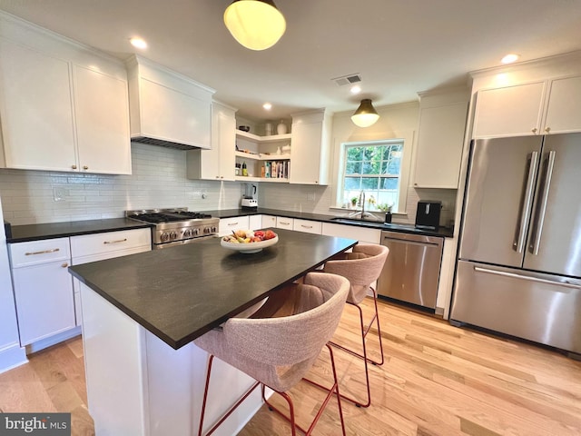 3200 Winnett Rd, Chevy Chase, MD 20815 - kitchen with appliances with stainless steel finishes, open shelves, light wood finished floors, white cabinets, and recessed lighting