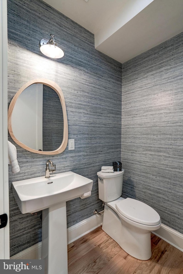 3200 Winnett Rd, Chevy Chase, MD 20815 - half bathroom with toilet, baseboards, wood finished floors, a sink, and wallpapered walls