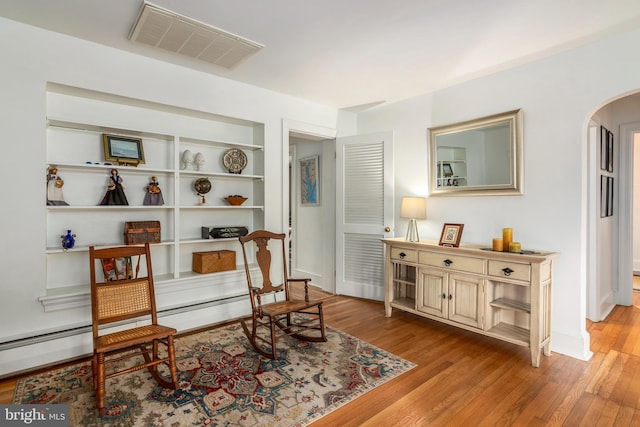 1110 Holland Ave, Cambridge, MD 21613 - sitting room featuring arched walkways, light wood-style floors, and built in shelves