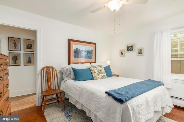 1110 Holland Ave, Cambridge, MD 21613 - bedroom featuring wood finished floors, baseboard heating, baseboards, and ceiling fan
