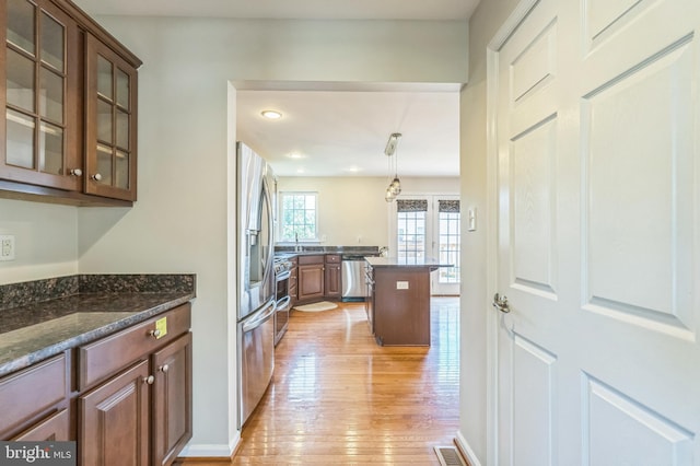 102 Helen Dr, Cinnaminson, NJ 08077 - kitchen featuring appliances with stainless steel finishes, light wood-type flooring, glass insert cabinets, dark stone counters, and a sink