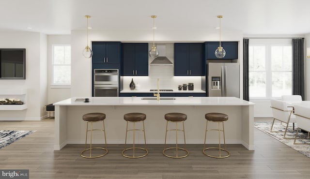 6253 Folly Ln, Alexandria, VA 22315 - kitchen with appliances with stainless steel finishes, blue cabinets, wall chimney exhaust hood, a sink, and a kitchen breakfast bar