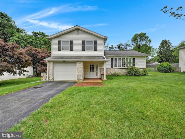 1122 Sheffield Dr, Berwyn, PA 19312 - tri-level home with stone siding, asphalt driveway, a garage, and a front lawn