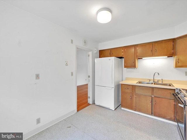 1122 Sheffield Dr, Berwyn, PA 19312 - kitchen with freestanding refrigerator, a sink, stainless steel range with electric stovetop, brown cabinets, and light countertops