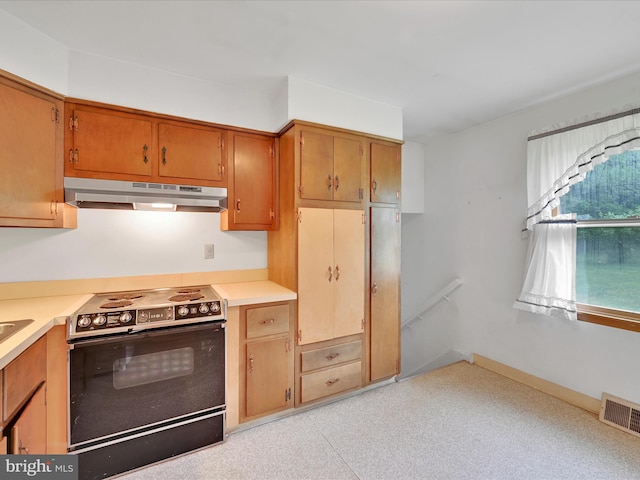 1122 Sheffield Dr, Berwyn, PA 19312 - kitchen featuring under cabinet range hood, electric range, light countertops, and brown cabinets