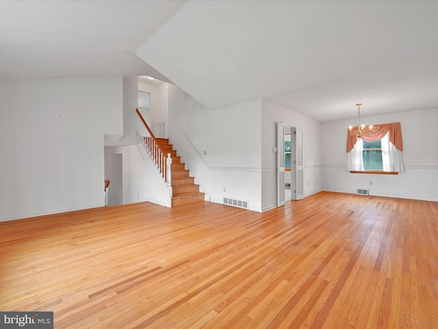 1122 Sheffield Dr, Berwyn, PA 19312 - unfurnished living room featuring light wood-style flooring, a chandelier, and stairs