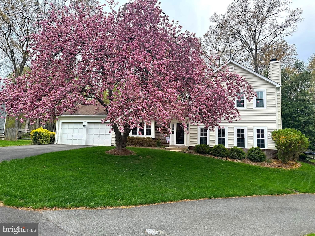 5911 Oak Leather Dr, Burke, VA 22015 - view of property hidden behind natural elements featuring a chimney, driveway, and a front lawn