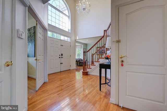 5 Pierce Rd, East Windsor, NJ 08520 - foyer entrance featuring stairway, light wood-style flooring, a chandelier, baseboards, and a high ceiling