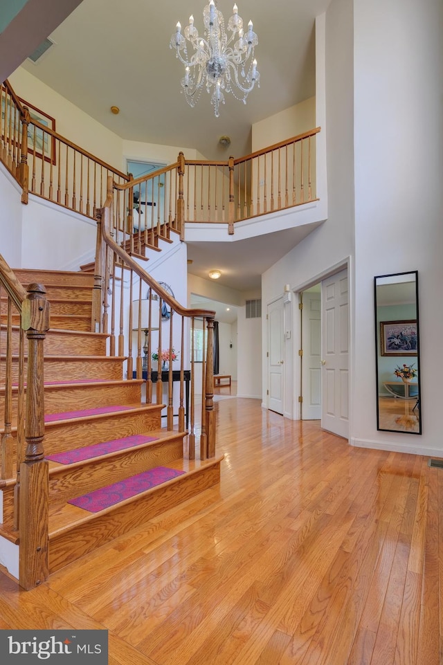5 Pierce Rd, East Windsor, NJ 08520 - stairway featuring a chandelier, a towering ceiling, wood finished floors, and baseboards