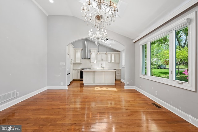 826 Suffolk Rd, Jenkintown, PA 19046 - unfurnished living room featuring arched walkways, lofted ceiling, light wood-style flooring, baseboards, and a chandelier