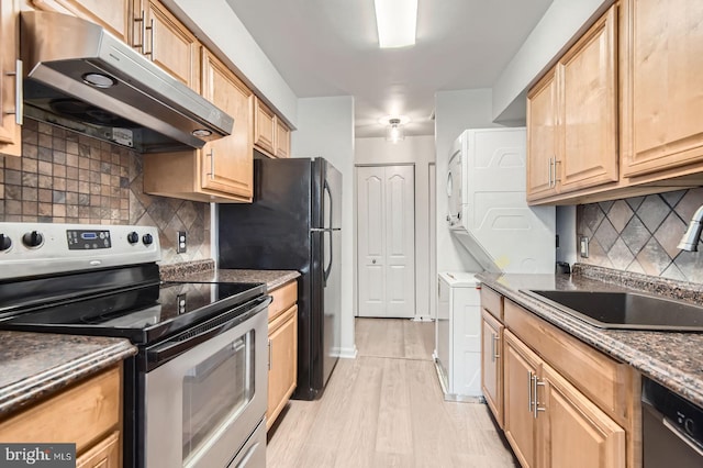 8385 Montgomery Run Rd Unit G, Ellicott City, MD 21043 - kitchen with stainless steel appliances, under cabinet range hood, estacked washer and dryer, a sink, and decorative backsplash