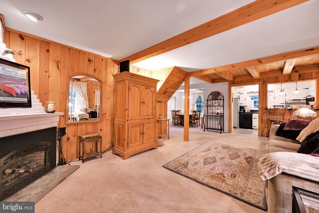 210 Pennsylvania Ave, Mount Gretna, PA 17064 - living area featuring wood walls, beam ceiling, light colored carpet, and a fireplace with raised hearth