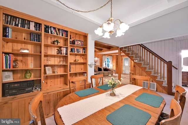 210 Pennsylvania Ave, Mount Gretna, PA 17064 - dining area with a chandelier, stairway, wooden walls, and beam ceiling