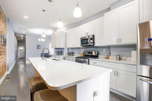 5E 27th St, Baltimore, MD 21218 - kitchen featuring appliances with stainless steel finishes, a sink, a center island with sink, dark wood finished floors, and white cabinets