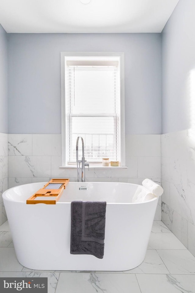 5E 27th St, Baltimore, MD 21218 - full bathroom with tile walls, marble finish flooring, plenty of natural light, wainscoting, and a freestanding bath