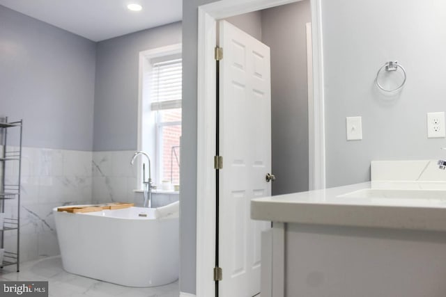 5E 27th St, Baltimore, MD 21218 - full bathroom with marble finish floors, plenty of natural light, a freestanding tub, and vanity