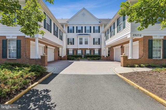 25272 Riffleford Sq Unit 104, Chantilly, VA 20152 - view of front facade with an attached garage, driveway, and brick siding