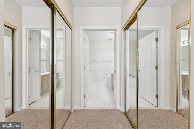 25272 Riffleford Sq Unit 104, Chantilly, VA 20152 - corridor with light carpet, baseboards, and a sink