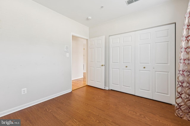 25272 Riffleford Sq Unit 104, Chantilly, VA 20152 - unfurnished bedroom featuring wood finished floors, a closet, and baseboards