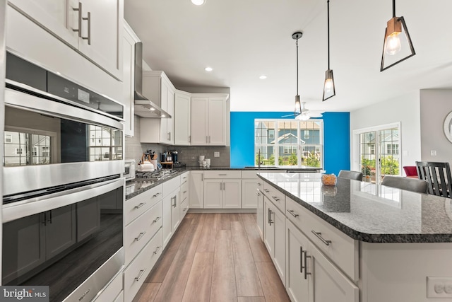 2042 Morgan Creek Dr, Quakertown, PA 18951 - kitchen with stainless steel appliances, recessed lighting, light wood-style floors, backsplash, and wall chimney exhaust hood