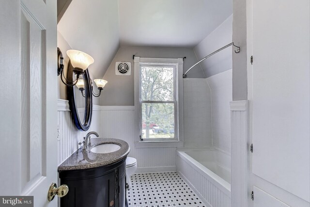 9112 3rd St, Lanham, MD 20706 - full bathroom with vaulted ceiling, toilet, vanity, washtub / shower combination, and a wainscoted wall
