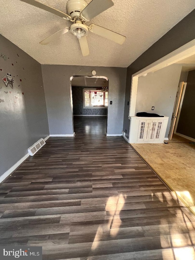 7119 Walker St, Philadelphia, PA 19135 - spare room with arched walkways, a textured ceiling, wood finished floors, ceiling fan, and baseboards