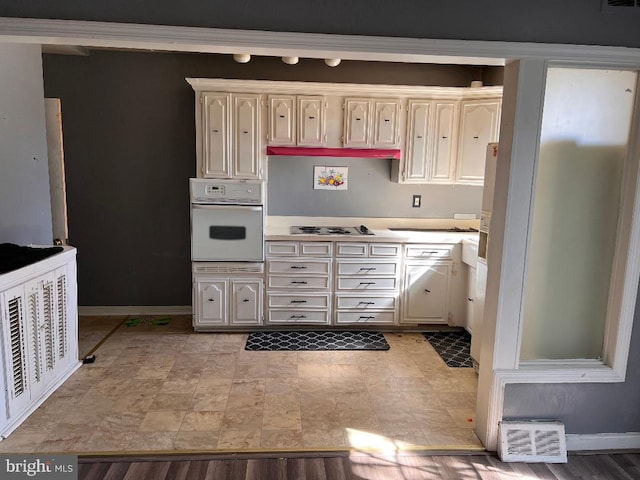 7119 Walker St, Philadelphia, PA 19135 - kitchen featuring oven, light countertops, baseboards, and stainless steel cooktop