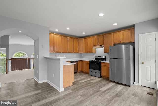 17504 Cajun Ct, Dumfries, VA 22025 - kitchen featuring appliances with stainless steel finishes, under cabinet range hood, light countertops, arched walkways, and recessed lighting