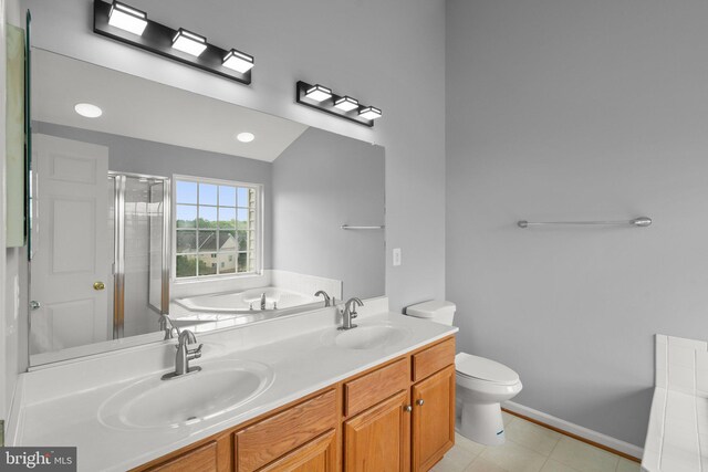 17504 Cajun Ct, Dumfries, VA 22025 - bathroom featuring a stall shower, toilet, a garden tub, baseboards, and double vanity