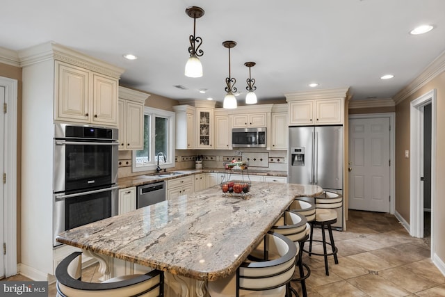 109 Johnson Ave, Oaklyn, NJ 08107 - kitchen with stainless steel appliances, cream cabinets, baseboards, a breakfast bar area, and recessed lighting
