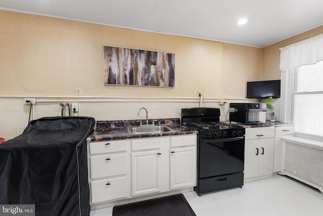 1419 Ellsworth St, Philadelphia, PA 19146 - kitchen featuring black gas range, a sink, radiator, white cabinets, and recessed lighting