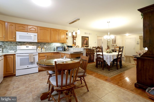 128 Penns Ct, Centre Hall, PA 16828 - kitchen with white appliances, a chandelier, tasteful backsplash, and light countertops