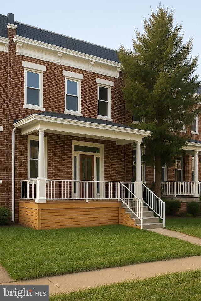 5012 Denmore Ave, Baltimore, MD 21215 - view of front of home with covered porch, brick siding, and a front yard
