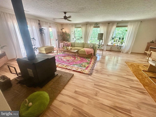 415 Rolly Rd, Mount Jackson, VA 22842 - living room featuring wood finished floors, a textured ceiling, a ceiling fan, and a wood stove