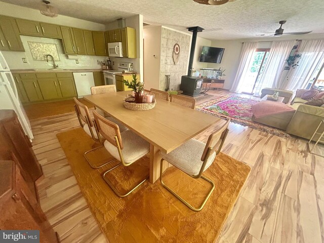 415 Rolly Rd, Mount Jackson, VA 22842 - dining room with a wood stove, a ceiling fan, a textured ceiling, and light wood-style flooring