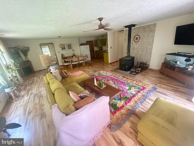 415 Rolly Rd, Mount Jackson, VA 22842 - living room with light wood-style floors, a wood stove, a ceiling fan, and a textured ceiling