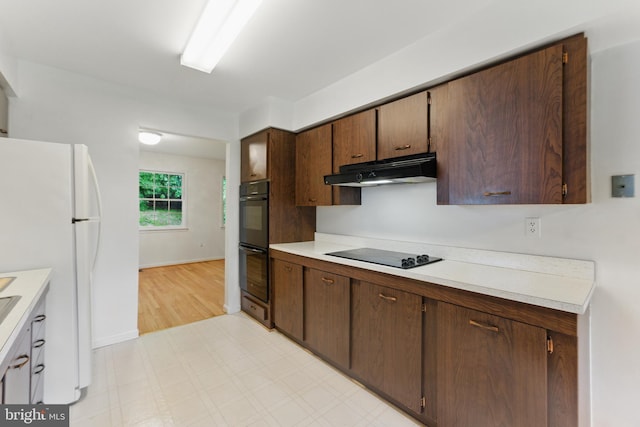 13021 Morningside Ln, Silver Spring, MD 20904 - kitchen with under cabinet range hood, black appliances, light countertops, light floors, and baseboards
