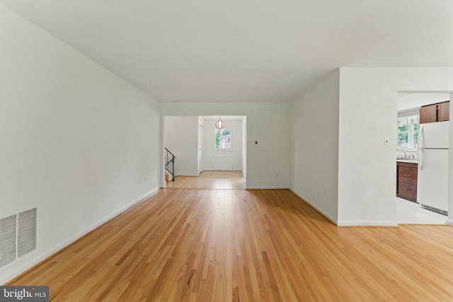 13021 Morningside Ln, Silver Spring, MD 20904 - unfurnished living room featuring light wood-style floors, baseboards, and a sink