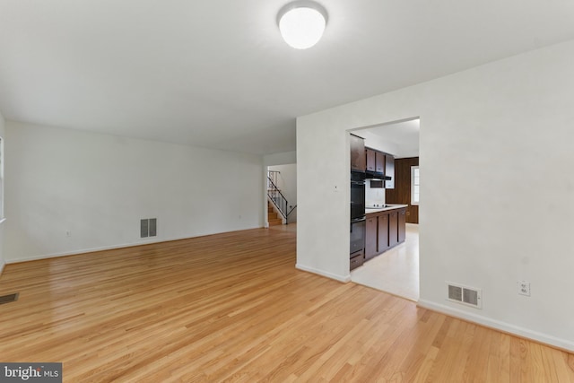 13021 Morningside Ln, Silver Spring, MD 20904 - unfurnished living room featuring light wood finished floors, stairway, and baseboards