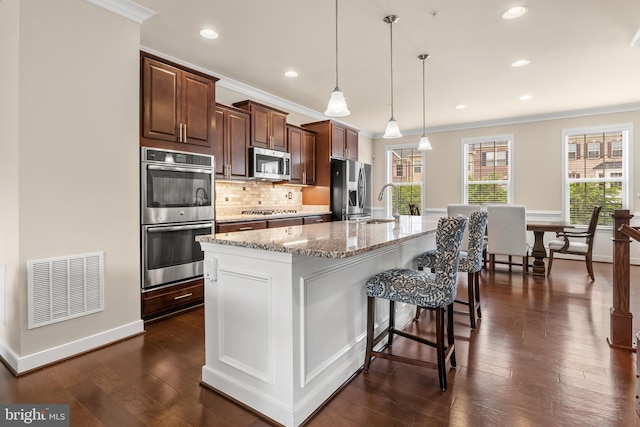 14039 Fox Hill Rd, Sparks, MD 21152 - kitchen featuring appliances with stainless steel finishes, crown molding, backsplash, a kitchen island with sink, and a breakfast bar