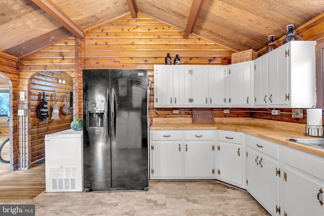 11621 Deadwood Dr, Lusby, MD 20657 - kitchen featuring black fridge with ice dispenser, log walls, wooden ceiling, light countertops, and white cabinets