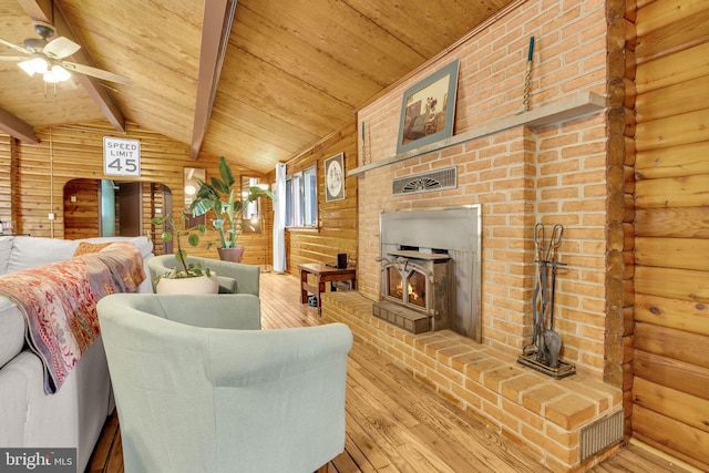11621 Deadwood Dr, Lusby, MD 20657 - living area with a wood stove, hardwood / wood-style floors, wooden ceiling, ceiling fan, and log walls