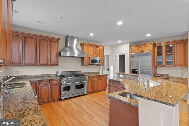 14603 Turner Wootton Pkwy, Upper Marlboro, MD 20774 - kitchen with high end appliances, a sink, wall chimney exhaust hood, brown cabinets, and recessed lighting