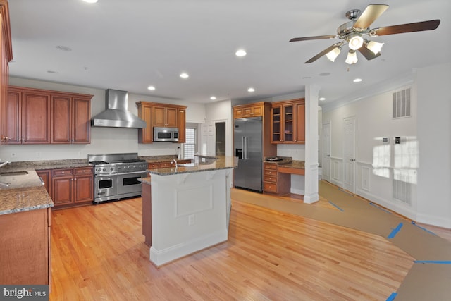 14603 Turner Wootton Pkwy, Upper Marlboro, MD 20774 - kitchen with premium appliances, wall chimney range hood, a ceiling fan, stone countertops, and light wood finished floors