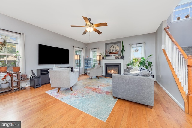 18 Basket Ct, Stafford, VA 22554 - living area featuring a glass covered fireplace, stairs, wood finished floors, ceiling fan, and baseboards