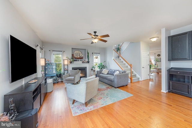 18 Basket Ct, Stafford, VA 22554 - living area featuring stairs, light wood finished floors, a glass covered fireplace, and a ceiling fan