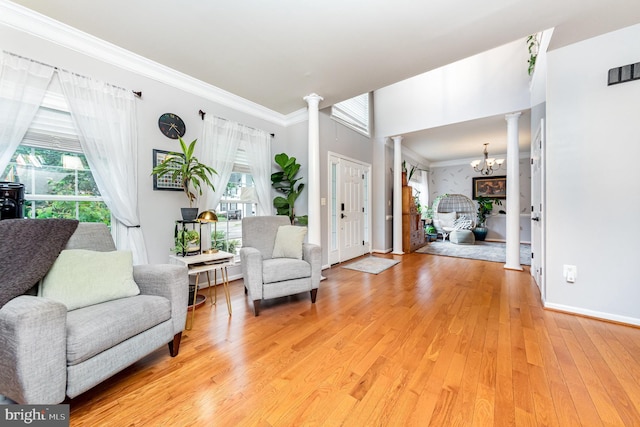 18 Basket Ct, Stafford, VA 22554 - sitting room featuring decorative columns, plenty of natural light, light wood-style floors, a chandelier, and crown molding