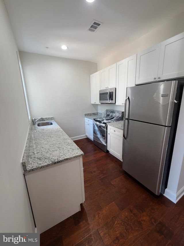 113 15th St SE, Washington, DC 20003 - kitchen with appliances with stainless steel finishes, white cabinets, light stone countertops, recessed lighting, and dark wood-style flooring